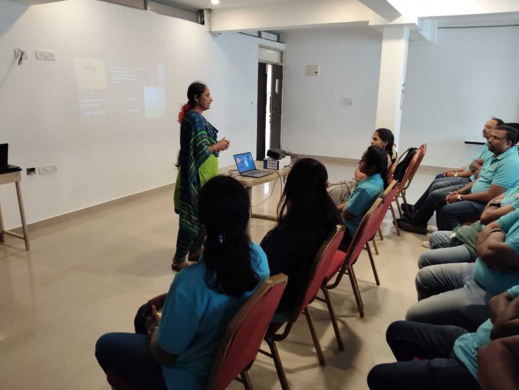 Corporate employees attending PoSH compliance training in Kannada and English.